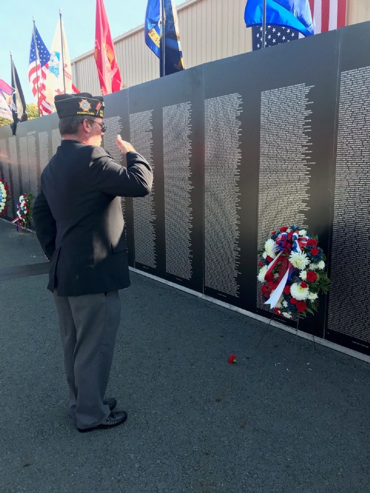 Past Commander Rick Ellis places a wreath at the moving Wall.